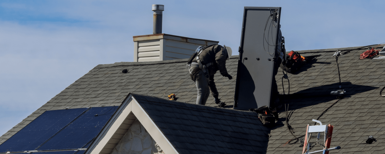 Solar Contractors removing a solar panel from the roof